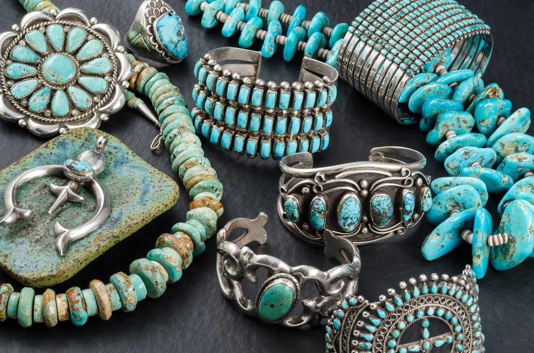Turquoise Jewelry, braclets, necklaces and pendants displayed on a black back grouns