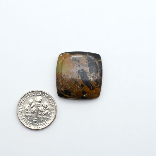 square shaped black & green turquoise cabochon on a white background with a dime for scale.