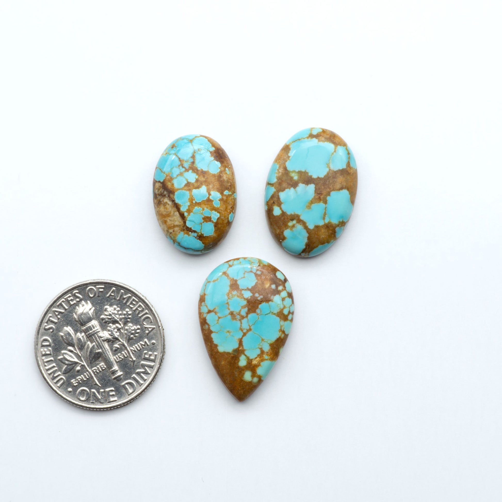 Three turquoise stones with brown matrix next to a U.S. dime on a white background Number 8 Turquoise Cabochons have been selected for their quality and unique appearance. Don't miss the chance to add a one-of-a-kind piece to your collection.