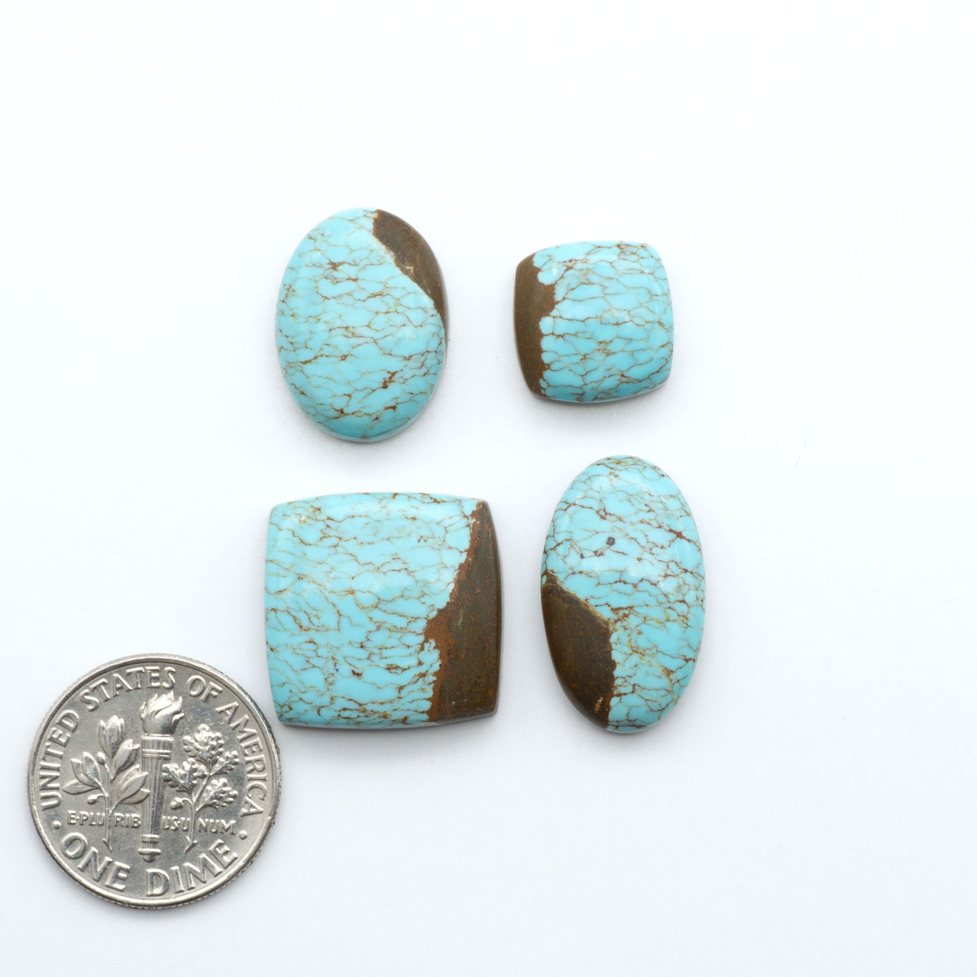 Four turquoise stones with brown accents on a white background, one next to a U.S. dime for size comparison. Number 8 Turquoise Cabochons have been selected for their quality and unique appearance. Don't miss the chance to add a one-of-a-kind piece to your collection.