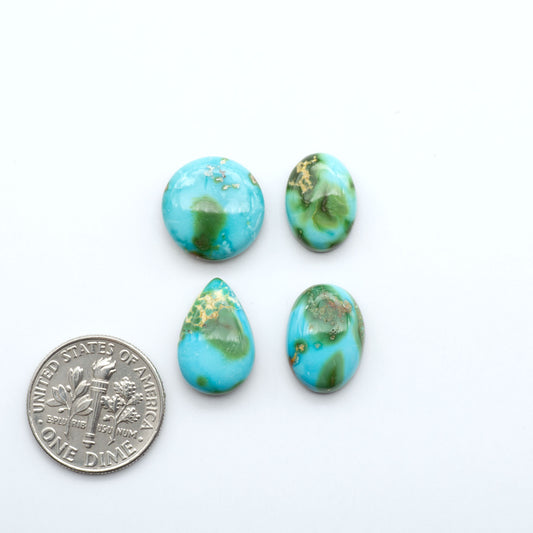Four turquoise stones of different shapes on a white background with a dime for scale.