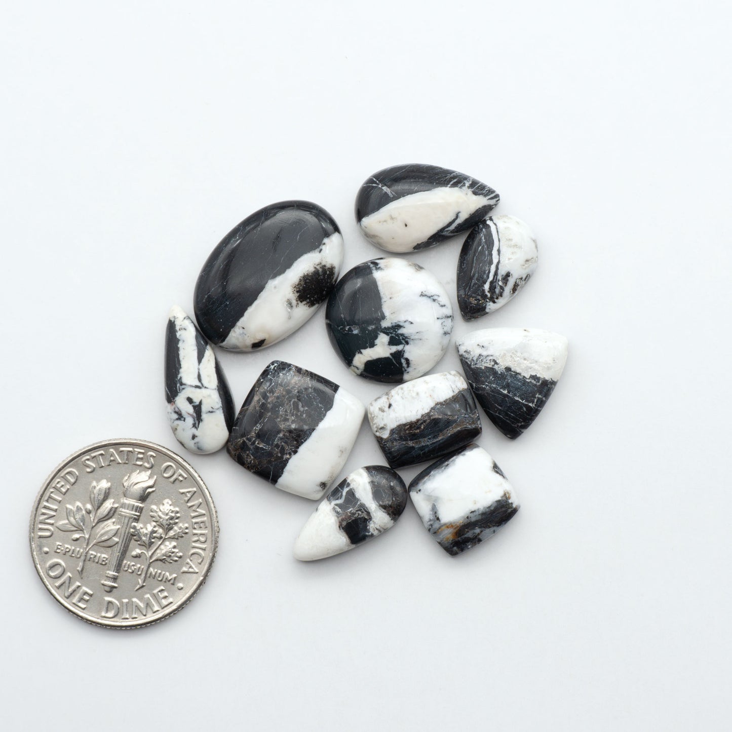 Black and white marbled stones with a U.S. dime for scale on a white background