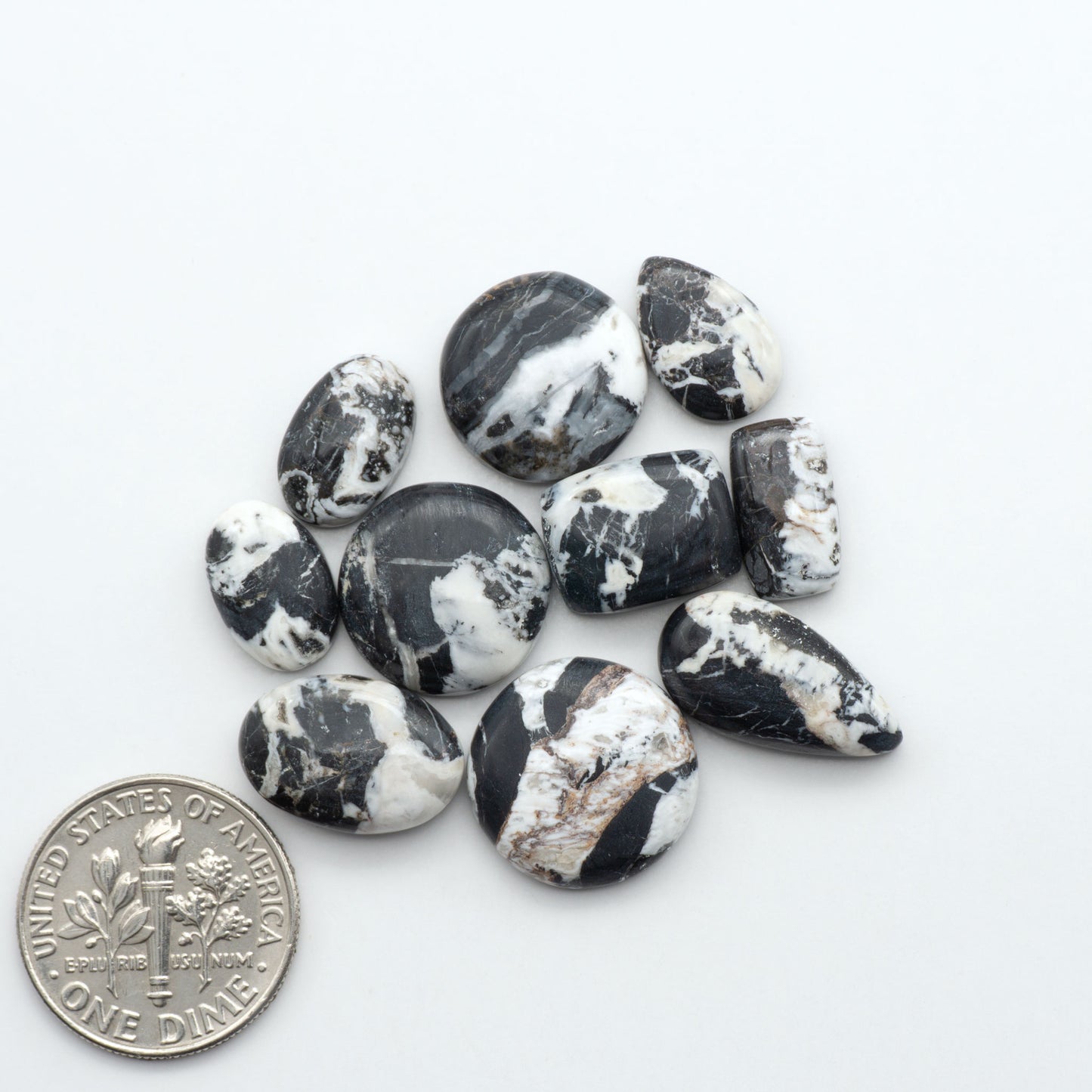 Black and white marbled stones with a U.S. dime for scale on a white background