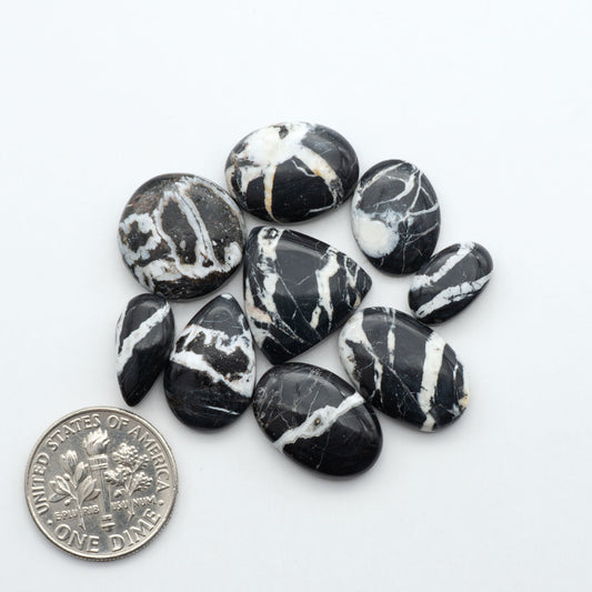 Black and white marbled stones with a U.S. dime for scale on a white background