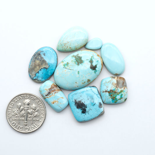 blue royston Turquoise stones with a U.S. dime for scale on a white background