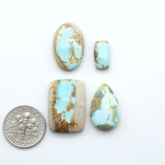 royston Turquoise stones with gold matrix with a dime for scale on a white background