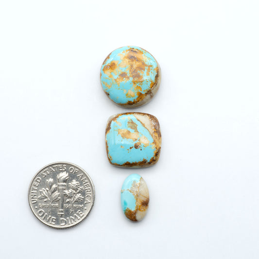 royston turquoise stones on a white bacground next to us dime for size comparison