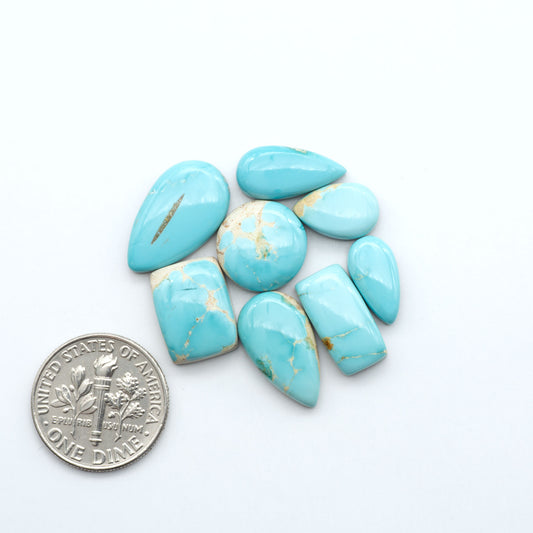 blue royston turquoise stones on a white background next to us dime for size comparison