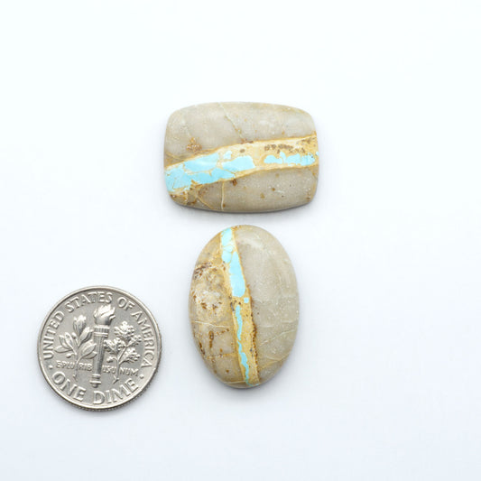 blue royston ribbon turquoise stones on a white background next to us dime for size comparison