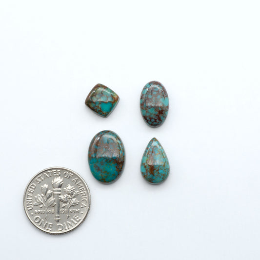 Sonoran Mountain turquoise cabochon lot blue green stones on white background with U.S. dime for size.