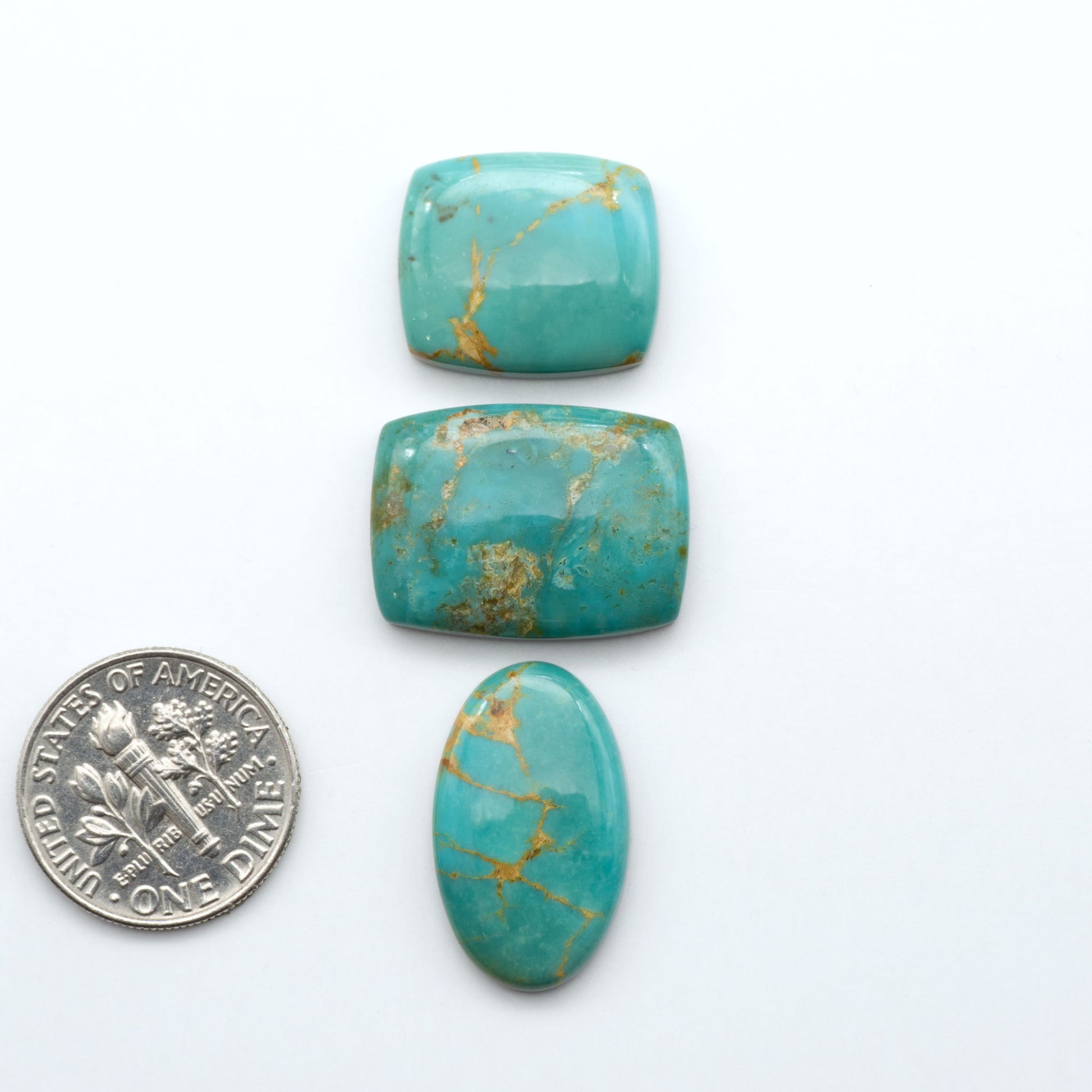 Turquoise Mountain turquoise cabochons, blue and green colors with natural matrix, polished stones on a white background, with a US dime for scale