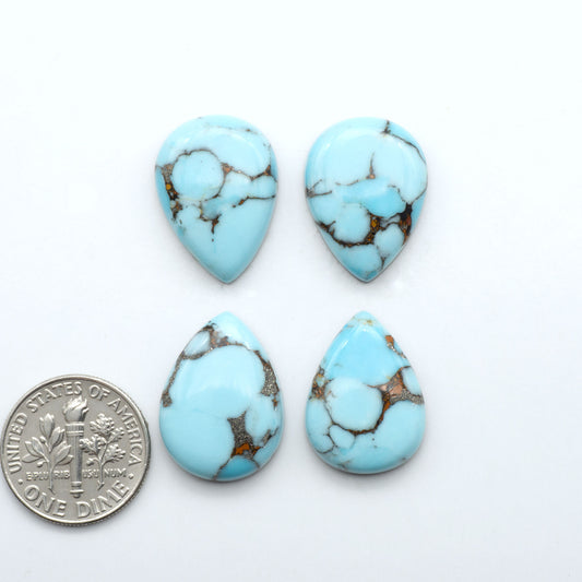 Pressed Turquoise nugget cabochons, stabilized composite with blue color and dark matrix on a white background, with a US dime for scale.