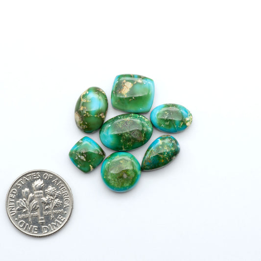 Sonoran Mountain Turquoise cabochons, blue-green color with natural matrix, polished stones on a white background with a US dime for scale