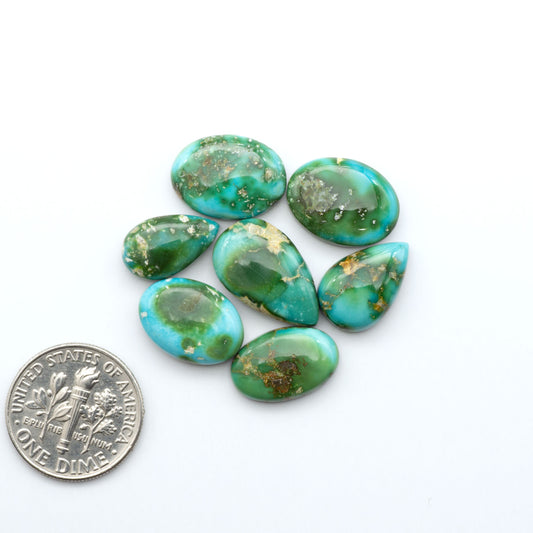 Sonoran Mountain Turquoise cabochons, blue-green color with natural matrix, polished stones on a white background with a US dime for scale