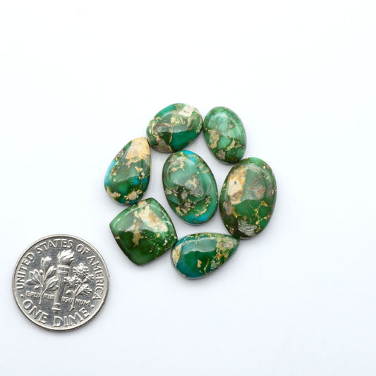 Sonoran Mountain Turquoise cabochons, blue-green color with natural matrix, polished stones on a white background with a US dime for scale