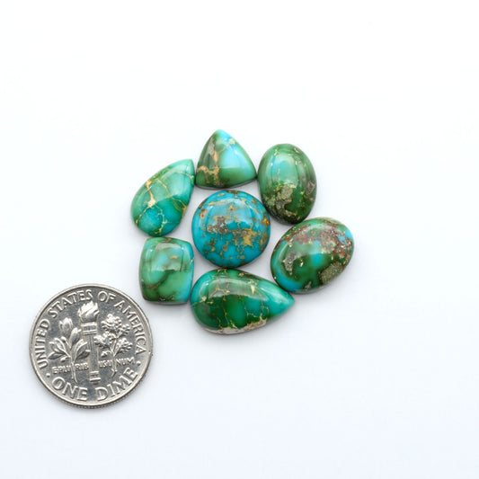 Sonoran Mountain Turquoise cabochons, blue-green color with natural matrix, polished stones on a white background with a US dime for scale