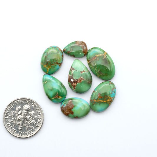 Sonoran Mountain Turquoise cabochons, blue-green color with natural matrix, polished stones on a white background with a US dime for scale