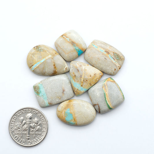 Royston Turquoise cabochons, blue-green color with natural matrix, polished stones on a white background, with a US dime for scale