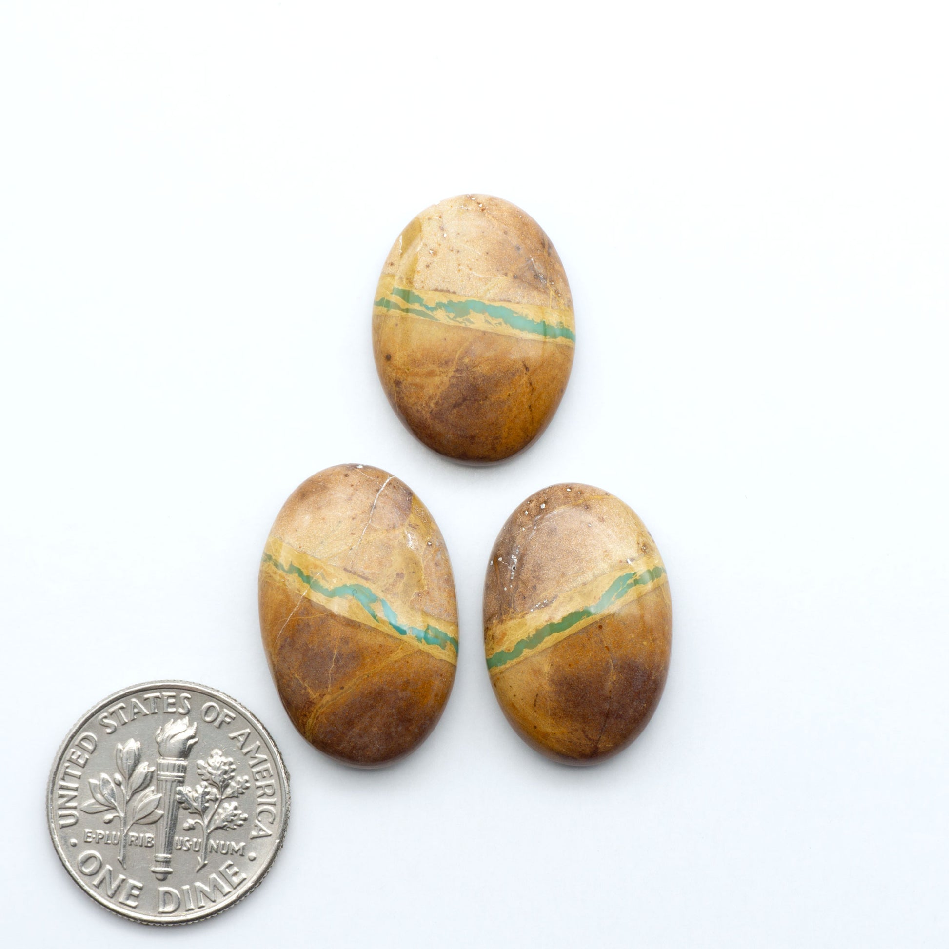 Royston Turquoise cabochons, blue-green color with natural matrix, polished stones on a white background, with a US dime for scale
