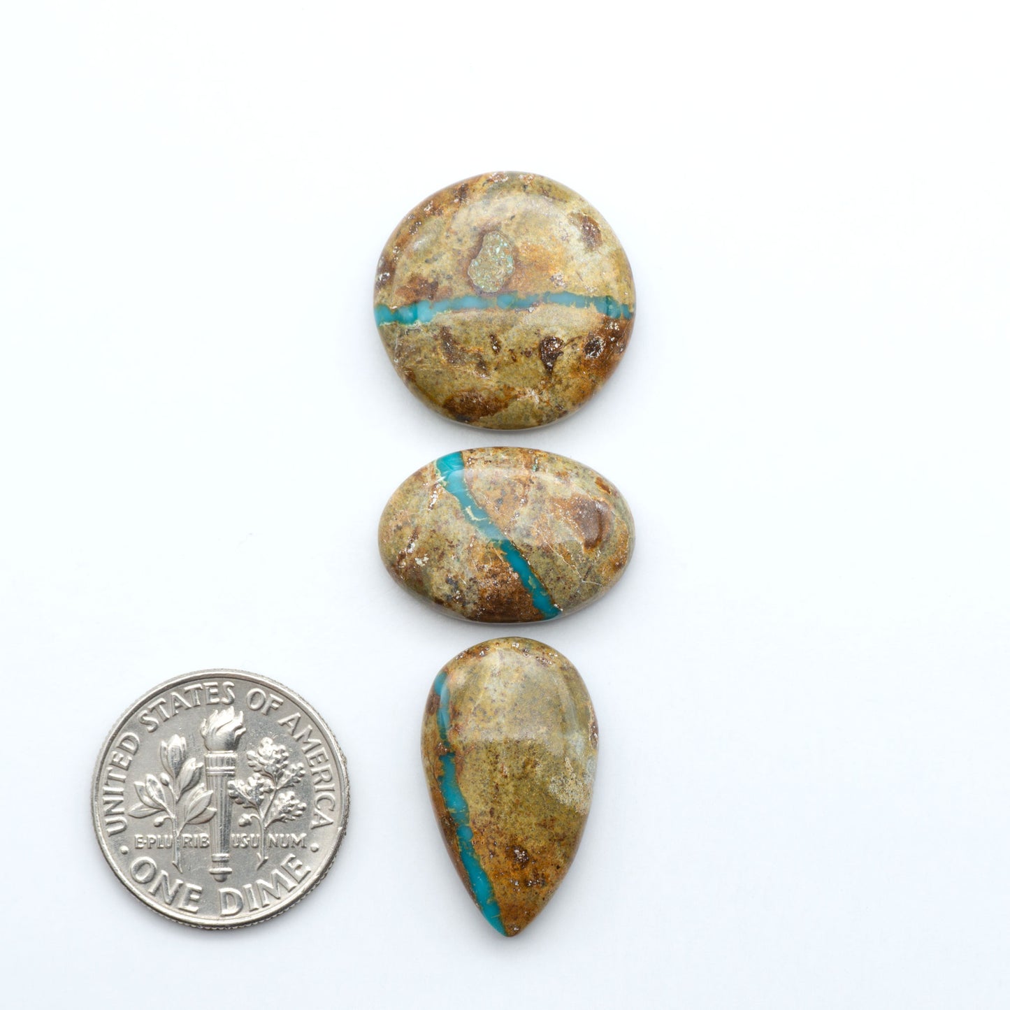 Royston Turquoise cabochons, blue-green color with natural matrix, polished stones on a white background, with a US dime for scale