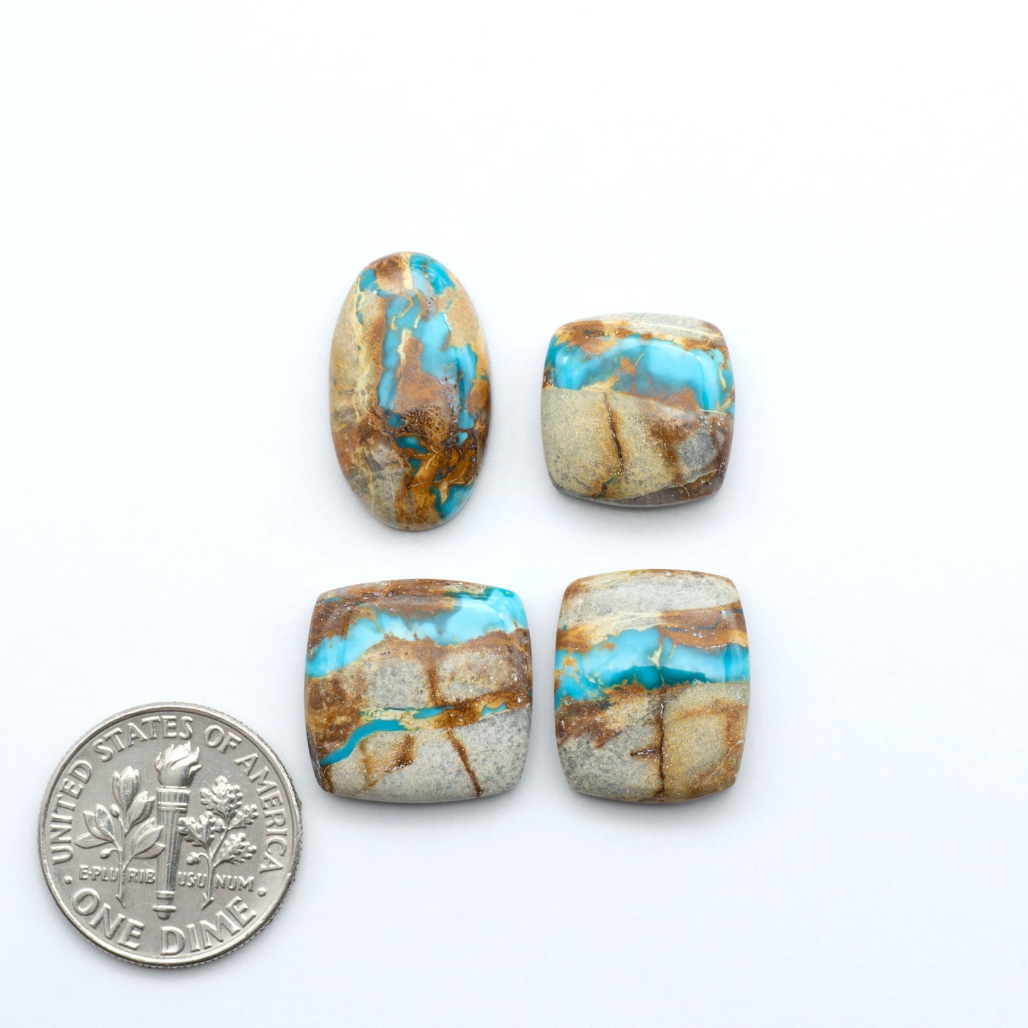 Royston Turquoise cabochons, blue-green color with natural matrix, polished stones on a white background, with a US dime for scale