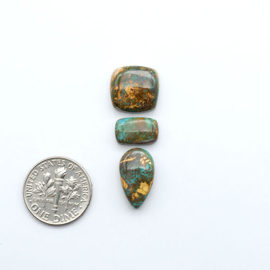 Royston Turquoise cabochons, blue-green color with natural matrix, polished stones on a white background, with a US dime for scale