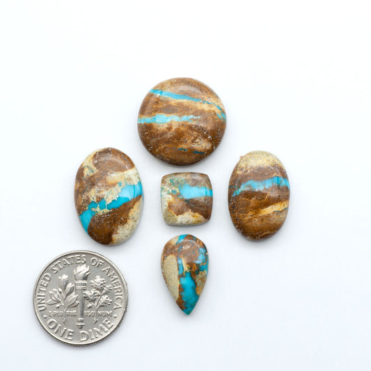 Royston Turquoise cabochons, blue-green color with natural matrix, polished stones on a white background, with a US dime for scale