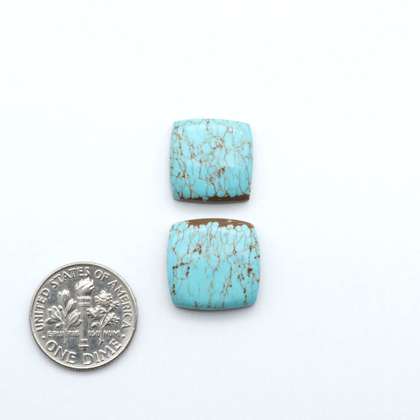 Number 8 Turquoise cabochons, blue and green color with brown matrix, polished stones on a white background, with a US dime for scale