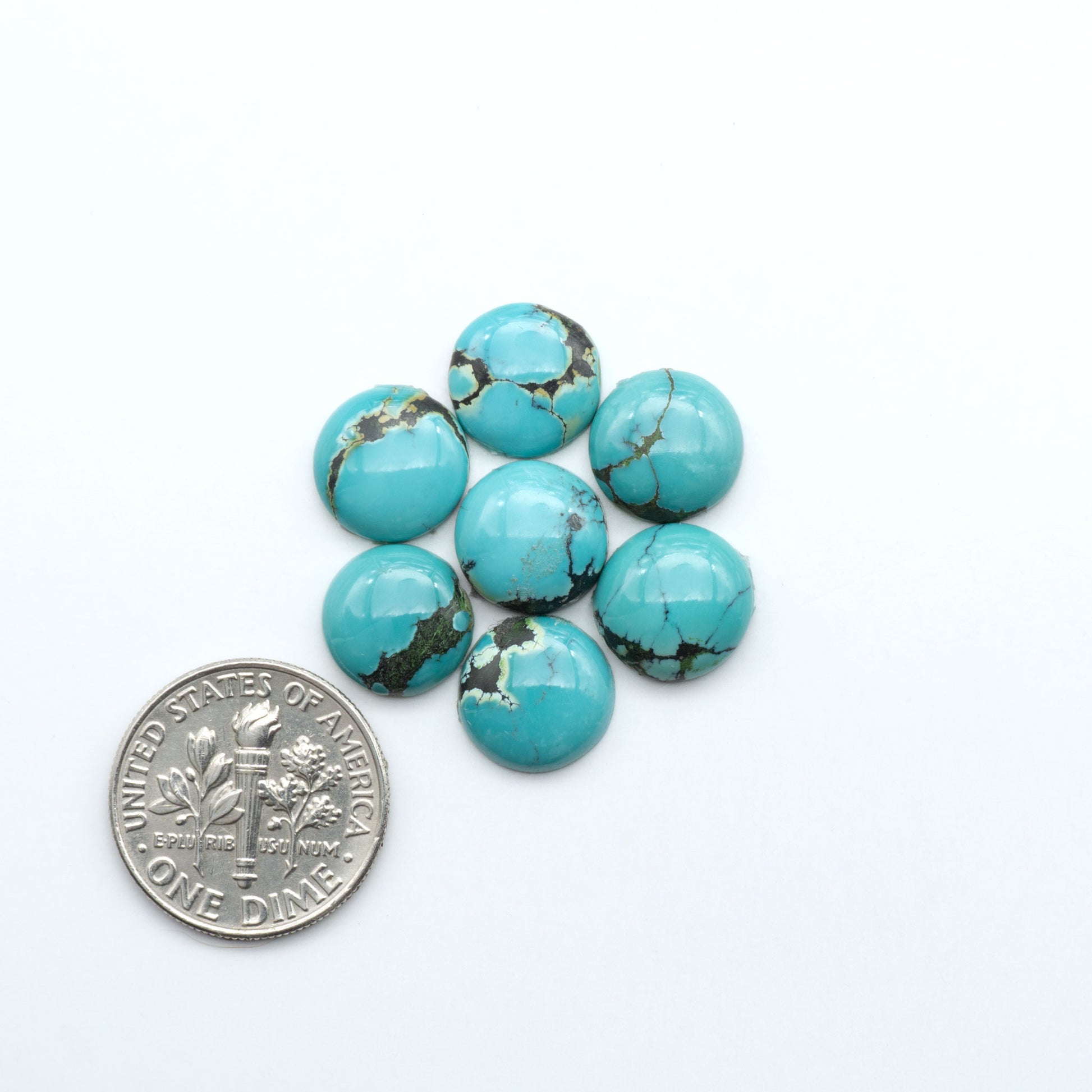 Hubei Cloud Mountain Turquoise cabochons, blue and green color with distinctive matrix, polished stones on a white background with a US dime for scale