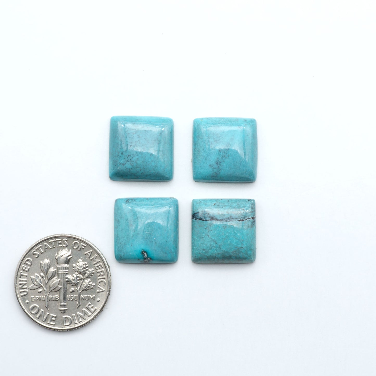 Hubei Cloud Mountain Turquoise cabochons, blue and green color with distinctive matrix, polished stones on a white background with a US dime for scale