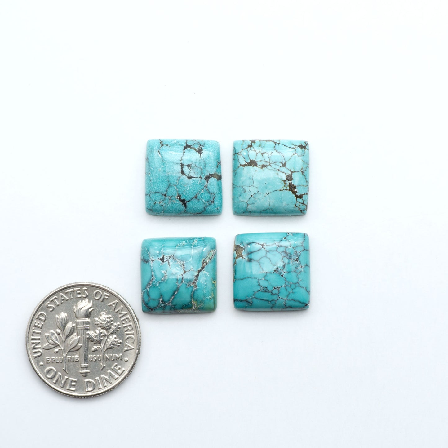 Hubei Cloud Mountain Turquoise cabochons, blue and green color with distinctive matrix, polished stones on a white background with a US dime for scale