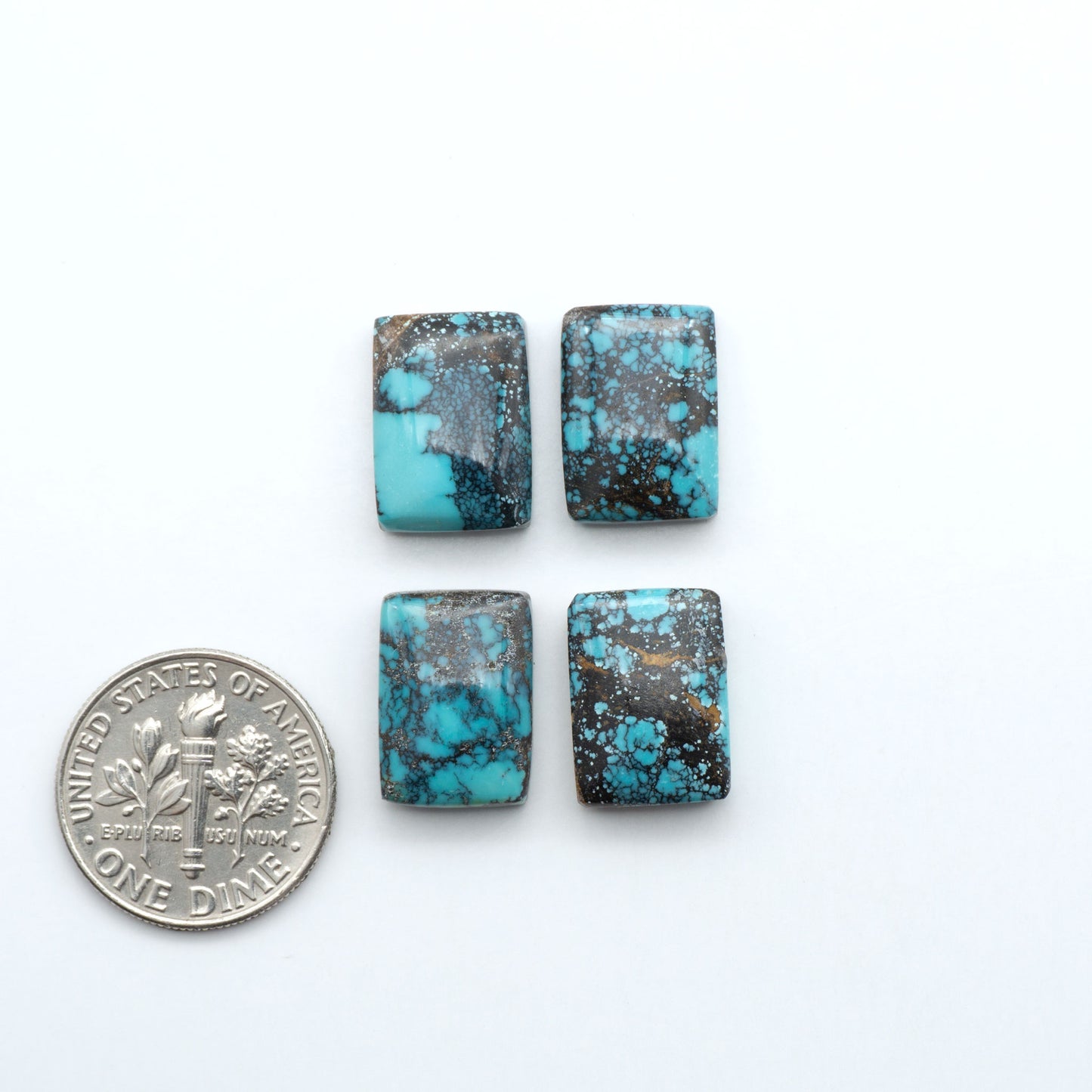 Hubei Cloud Mountain Turquoise cabochons, blue and green color with black matrix, polished stones on a white background with a US dime for scale