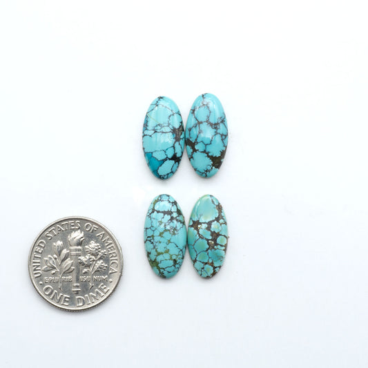 Hubei Cloud Mountain Turquoise cabochons, blue and green color with black matrix, polished stones on a white background with a US dime for scale
