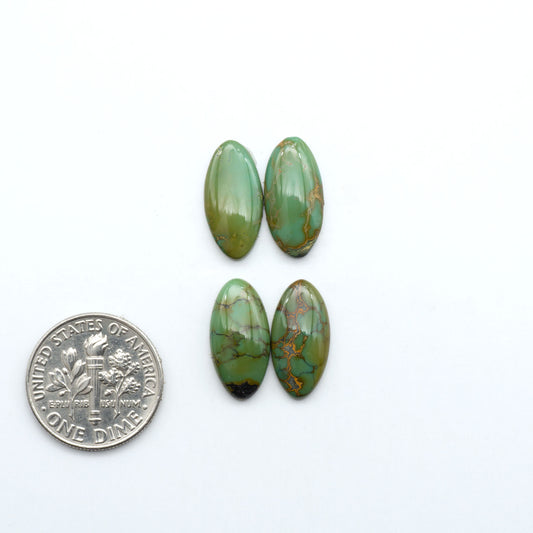 Hubei Cloud Mountain Turquoise cabochons, green color with black matrix, polished stones on a white background with a US dime for scale