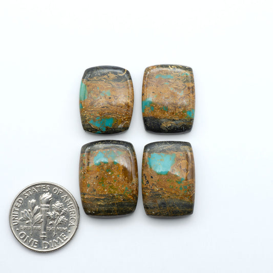Black Jack turquoise cabochons, blue-green color with black matrix, polished stones on a white background with a US dime for scale
