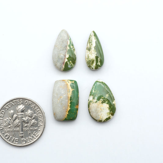 Royston Turquoise cabochons, blue-green color with natural matrix, polished stones on a white background, with a US dime for scale