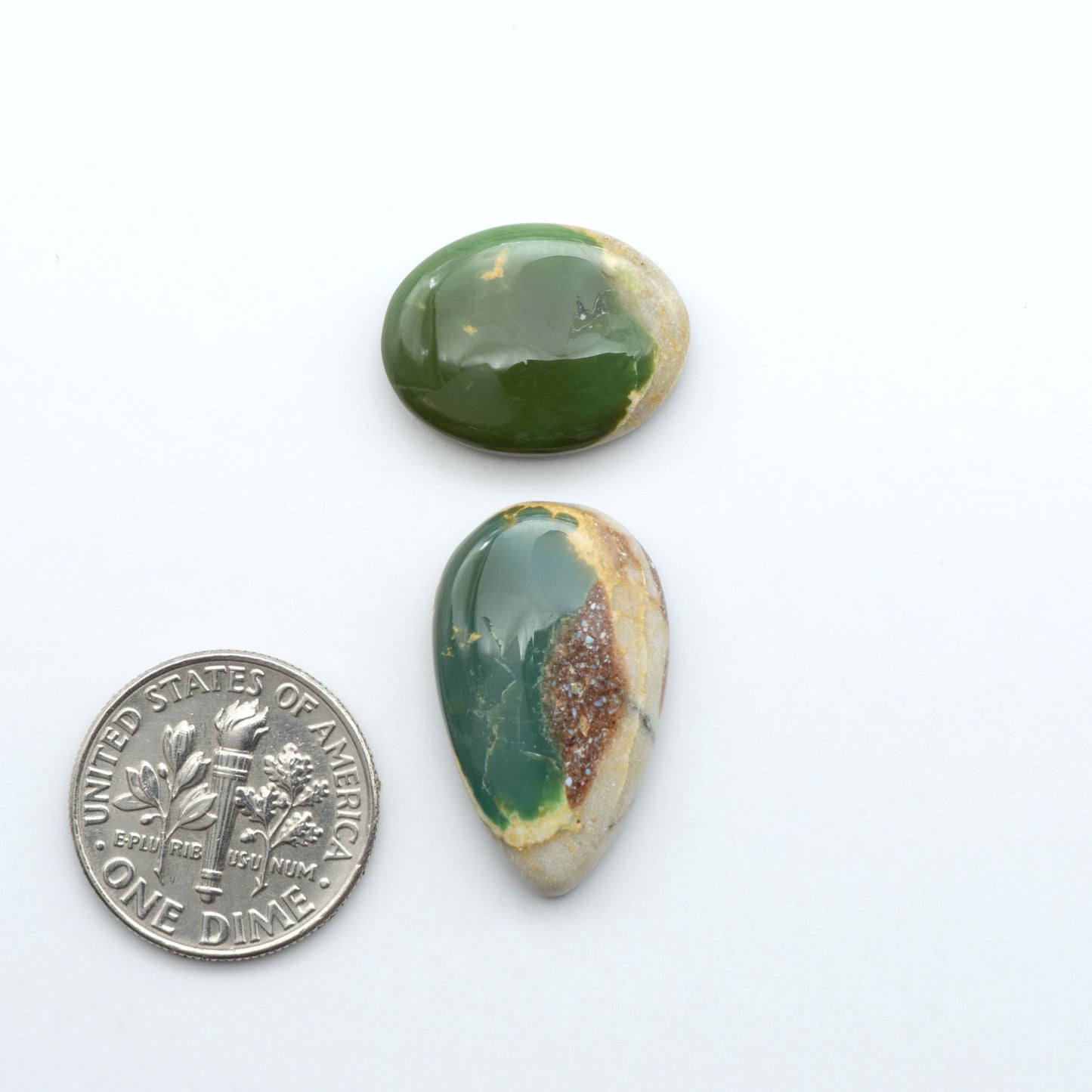 Royston Turquoise cabochons, blue-green color with natural matrix, polished stones on a white background, with a US dime for scale