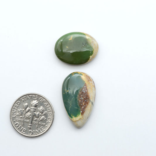 Royston Turquoise cabochons, blue-green color with natural matrix, polished stones on a white background, with a US dime for scale