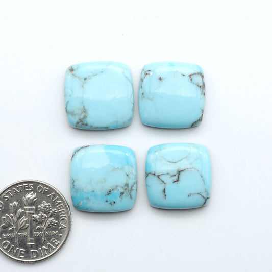 Pressed Turquoise nugget cabochons, composite material with a blue color and dark matrix on a white background, with a US dime for scale.