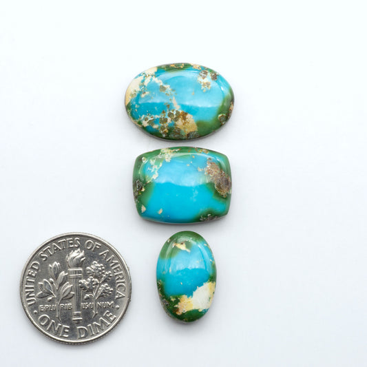 Sonoran Mountain Turquoise cabochons, blue-green color with natural matrix, polished stones on a white background, with a US dime for scale
