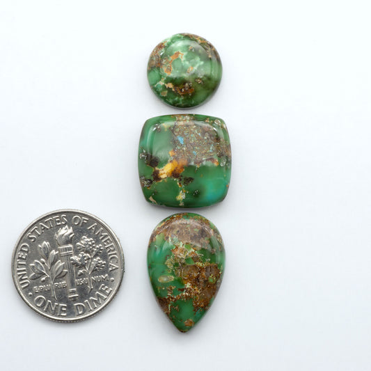 Sonoran Mountain Turquoise cabochons, blue-green color with natural matrix, polished stones on a white background, with a US dime for scale