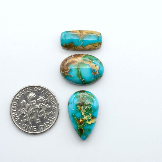 Sonoran Mountain Turquoise cabochons, blue-green color with natural matrix, polished stones on a white background, with a US dime for scale