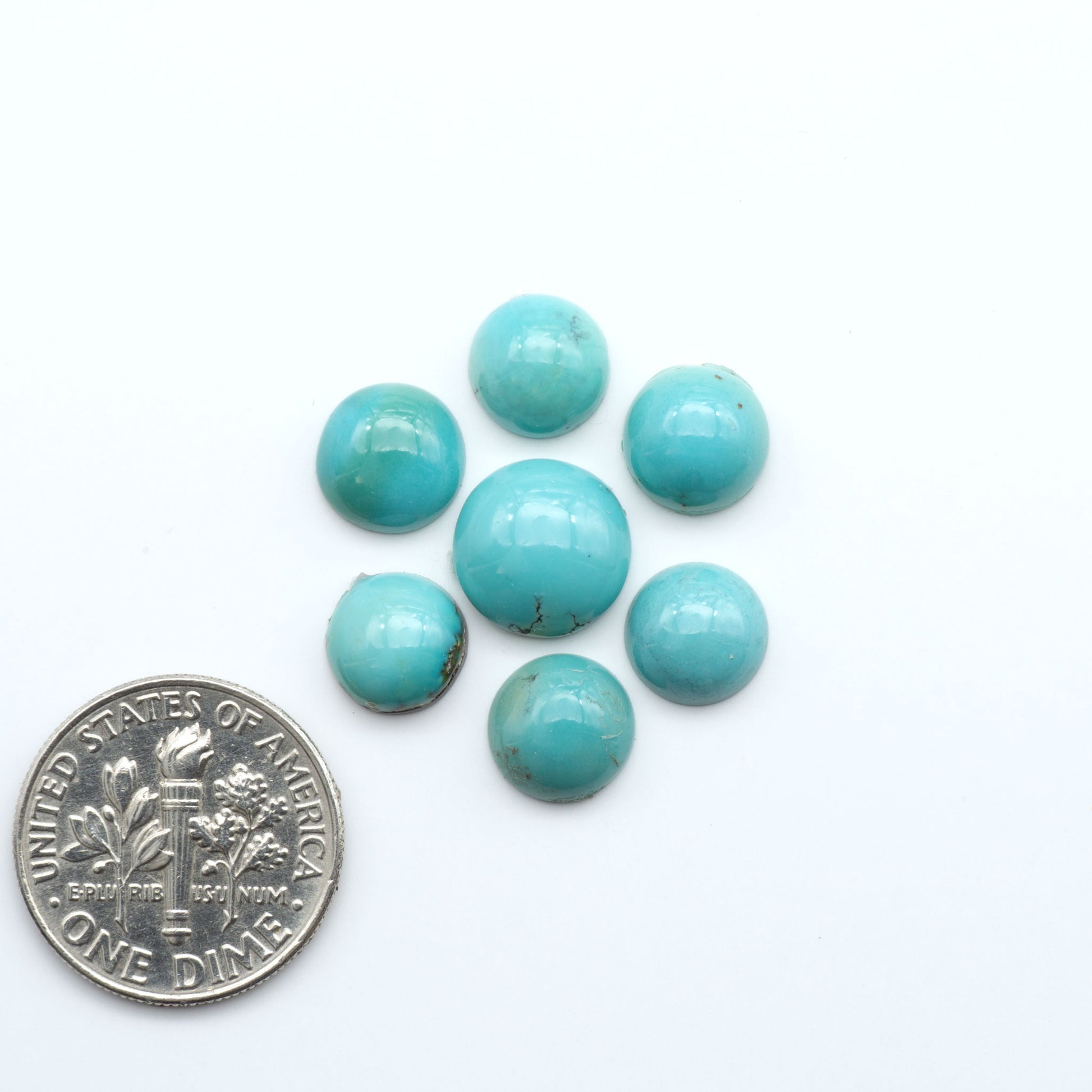 Hubei Cloud Mountain Turquoise cabochons, blue and green color with black matrix, polished stones on a white background with a US dime for scale