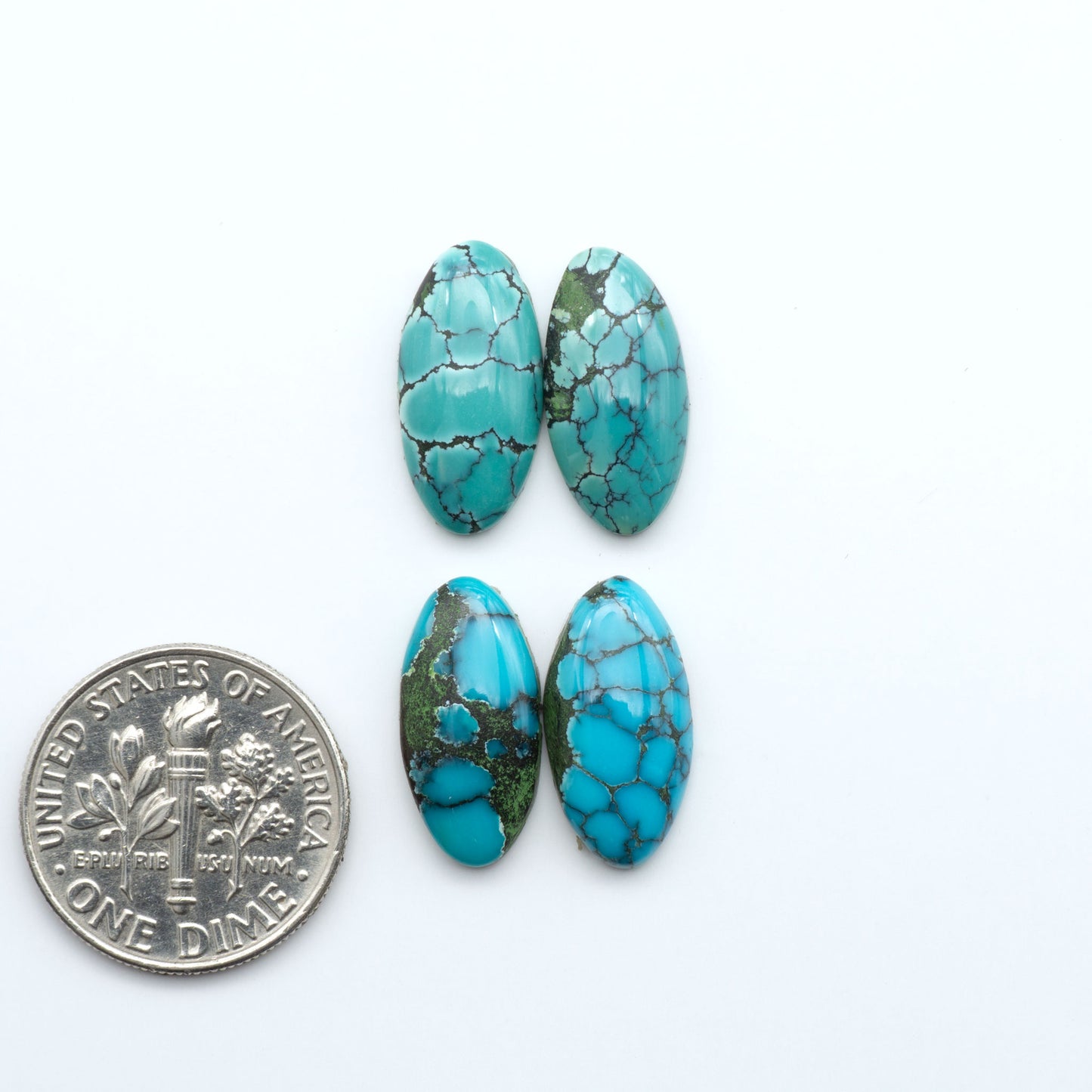 Hubei Cloud Mountain Turquoise cabochons, blue and green color with black matrix, polished stones on a white background with a US dime for scale