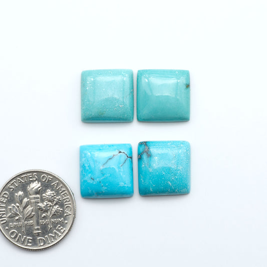 Hubei Cloud Mountain Turquoise cabochons, blue and green color with black matrix, polished stones on a white background with a US dime for scale