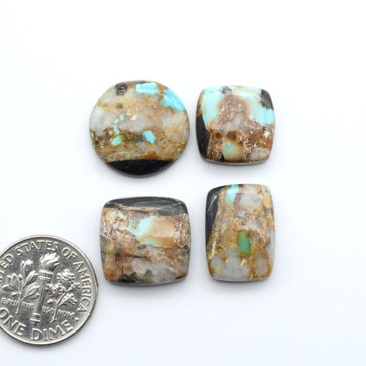 Black Jack turquoise cabochons, blue-green color with black matrix, polished stones on a white background with a US dime for scale