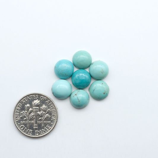 Hubei Cloud Mountain Turquoise cabochons, blue and green color with black matrix, polished stones on a white background, with a US dime for scale