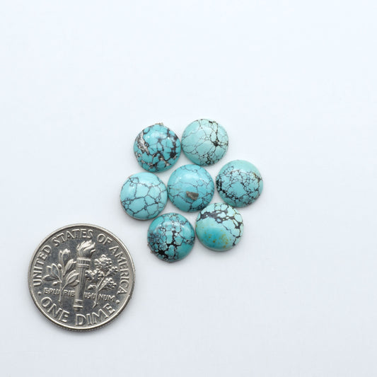 Hubei Cloud Mountain Turquoise cabochons, blue and green color with black matrix, polished stones on a white background, with a US dime for scale