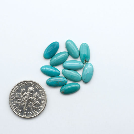 Hubei Cloud Mountain Turquoise cabochons, blue and green color with black matrix, polished stones on a white background, with a US dime for scale