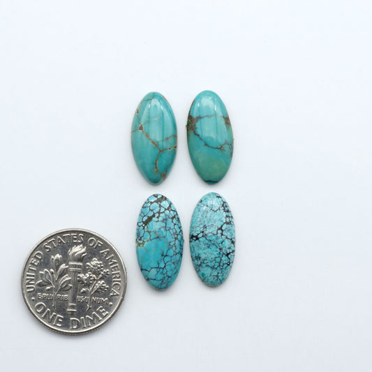 Hubei Cloud Mountain Turquoise cabochons, blue and green color with black matrix, polished stones on a white background, with a US dime for scale